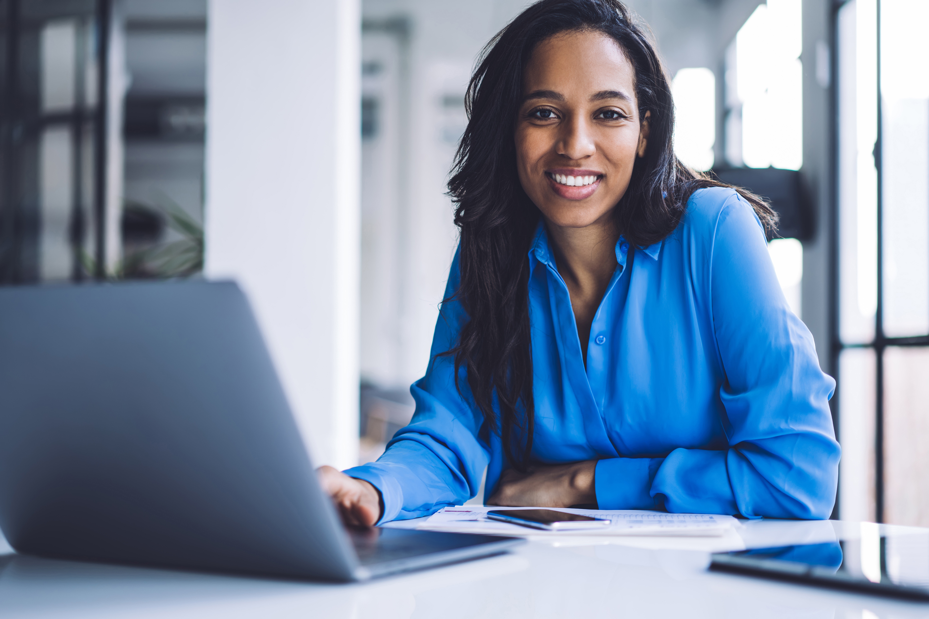 Smiling businesswoman using laptop at work